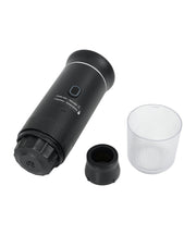 Black 3-in-1 portable espresso maker fully disassembled showing main unit, black capsule adapter, transparent collection cup, and all detachable components
